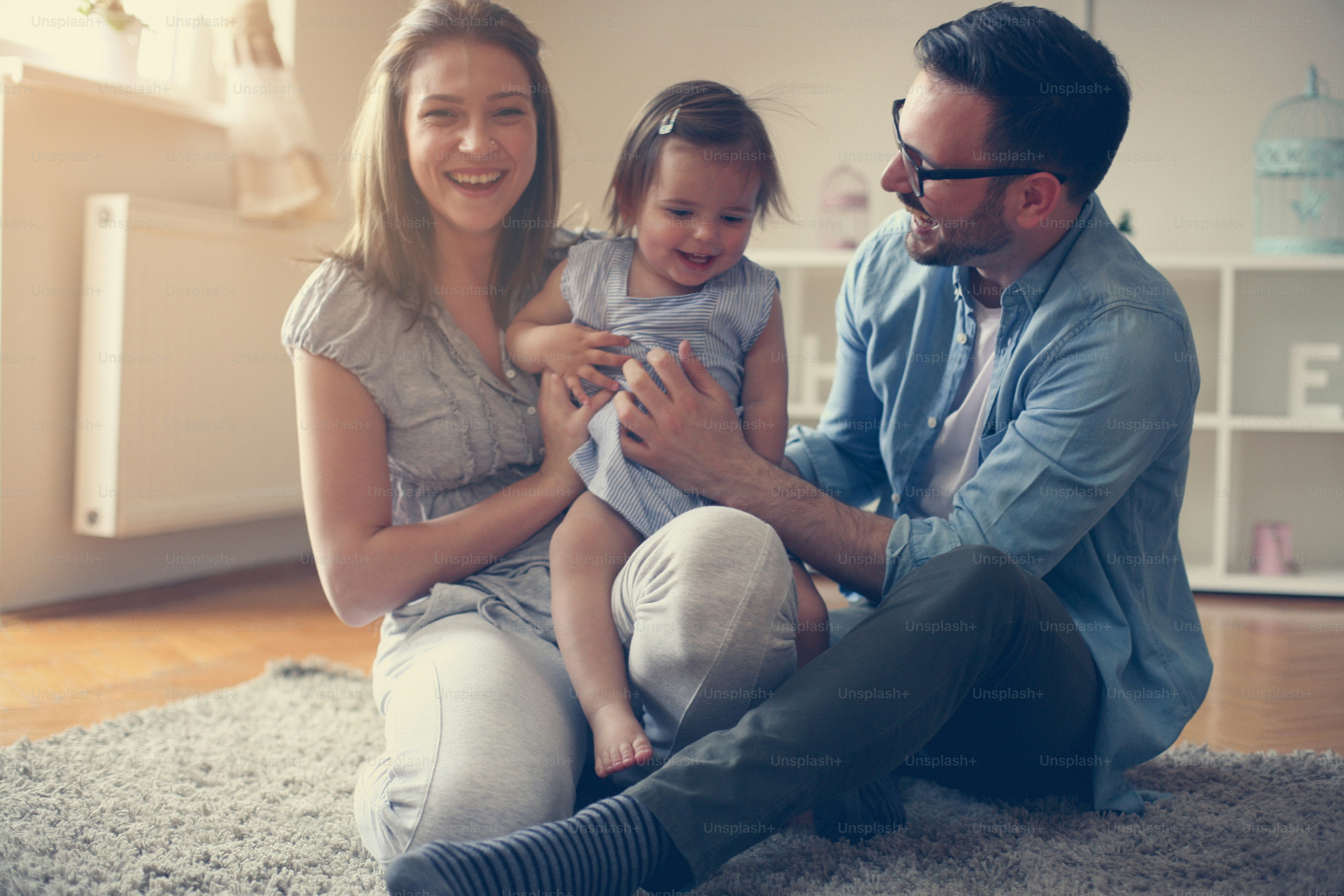 Foto Familia feliz sentada en el suelo con su pequeño bebé. Familia ...