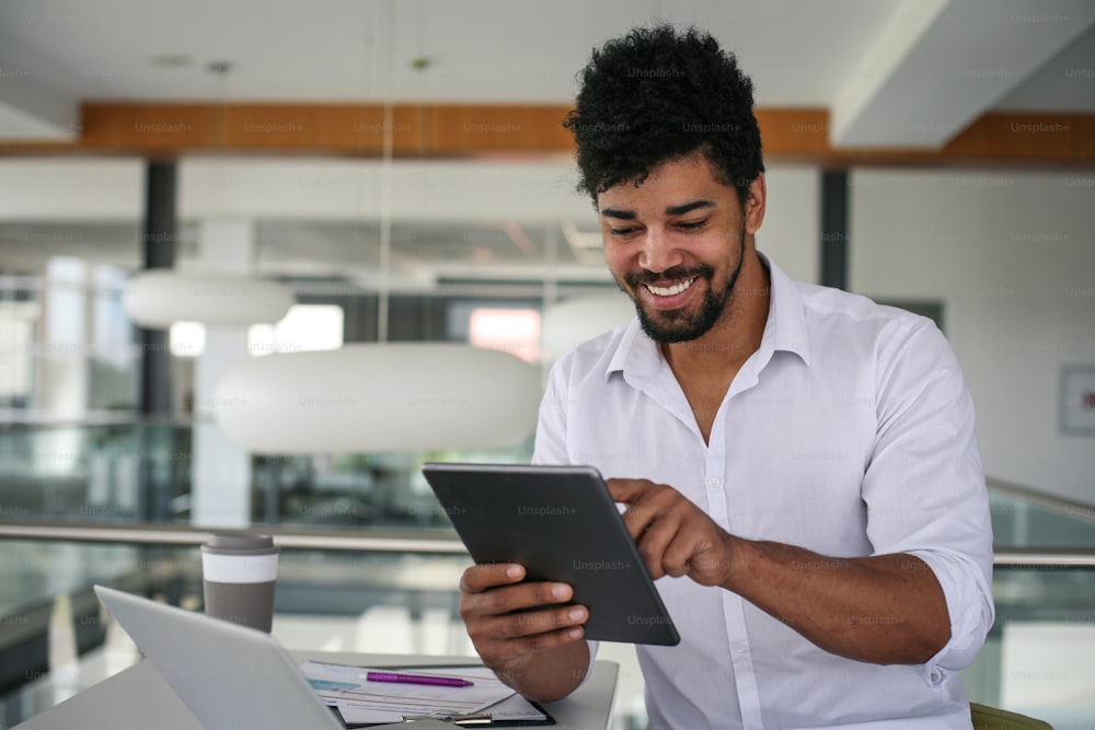 African American business man using digital tablet at the office. African man working on tablet.