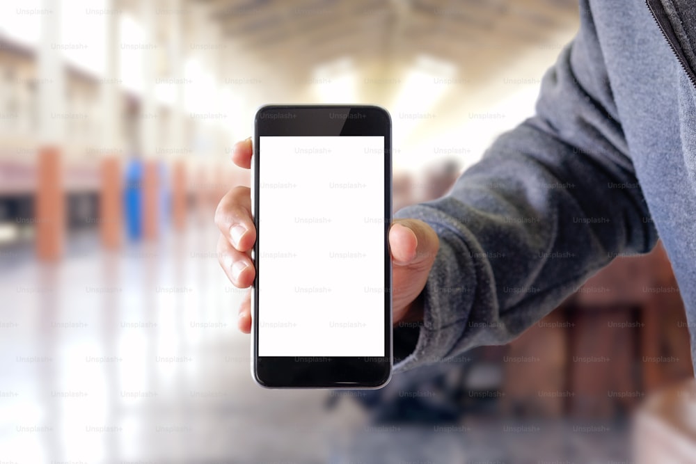 Hombre usando un teléfono inteligente en el ferrocarril. Smartphone con pantalla en blanco para montaje gráfico.