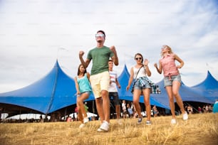 여름 음악 축제에서 십 대 소년 소녀들의 그룹, 큰 텐트 앞에서 춤, 화창한 날