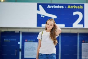 배낭을 메고 도착문에서 국제 공항에서 짐을 들고 다니는 아름다운 젊은 관광 소녀