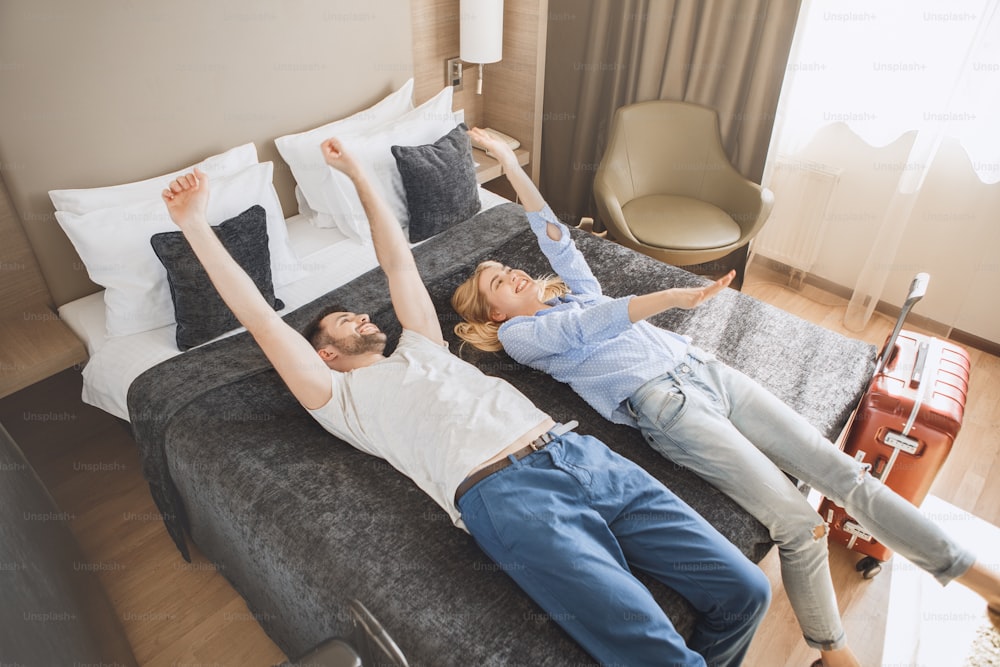 Young man and woman together tourism hotel lying on bed