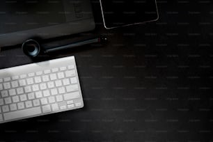 Table de bureau en cuir avec tablette de dessin numérique, fournitures et ordinateur. Vue de dessus avec espace de copie