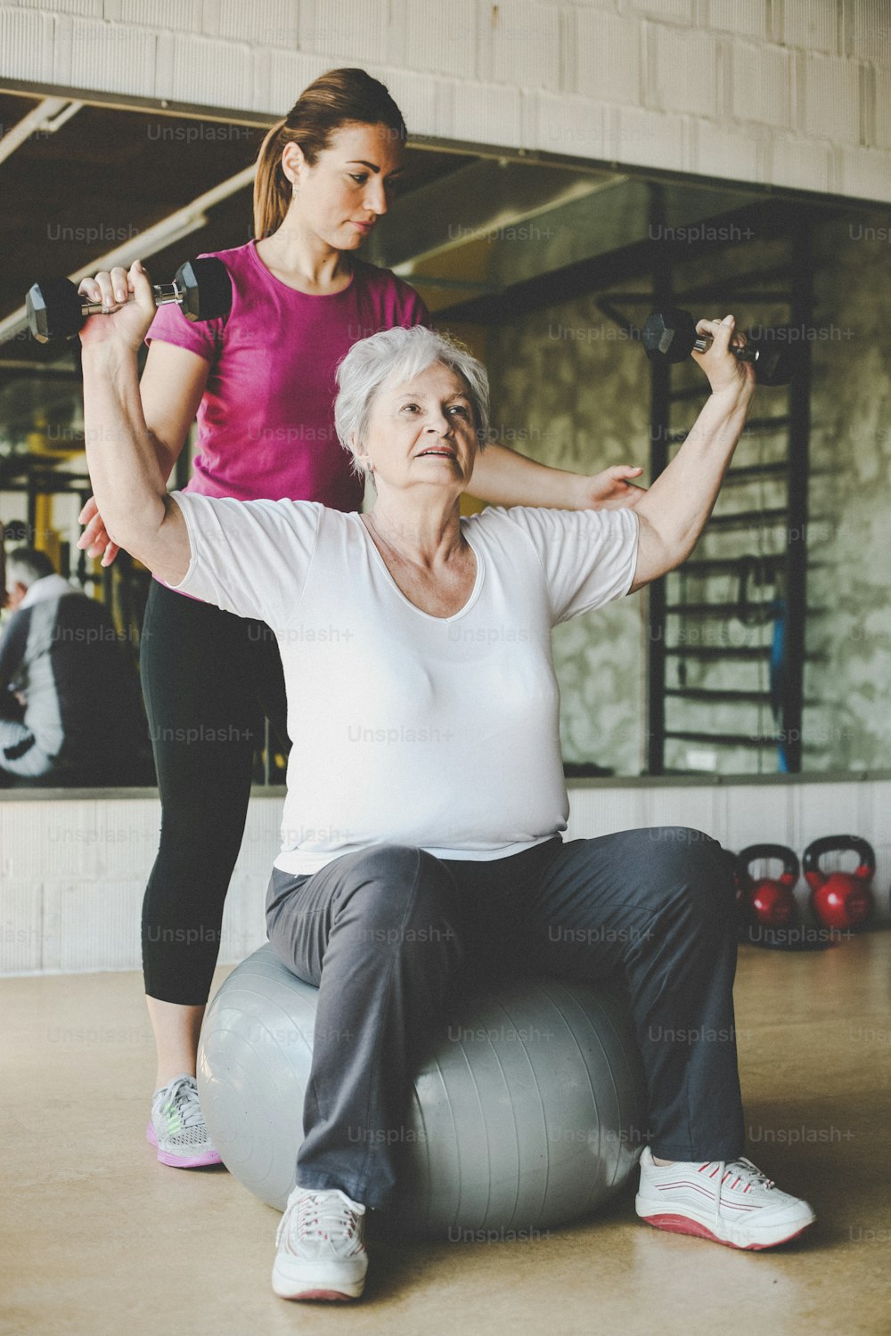 Senior woman workout in rehabilitation center. Personal trainer helping senior woman