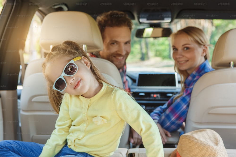 Travel by car family ride together daughter playing with sunglasses