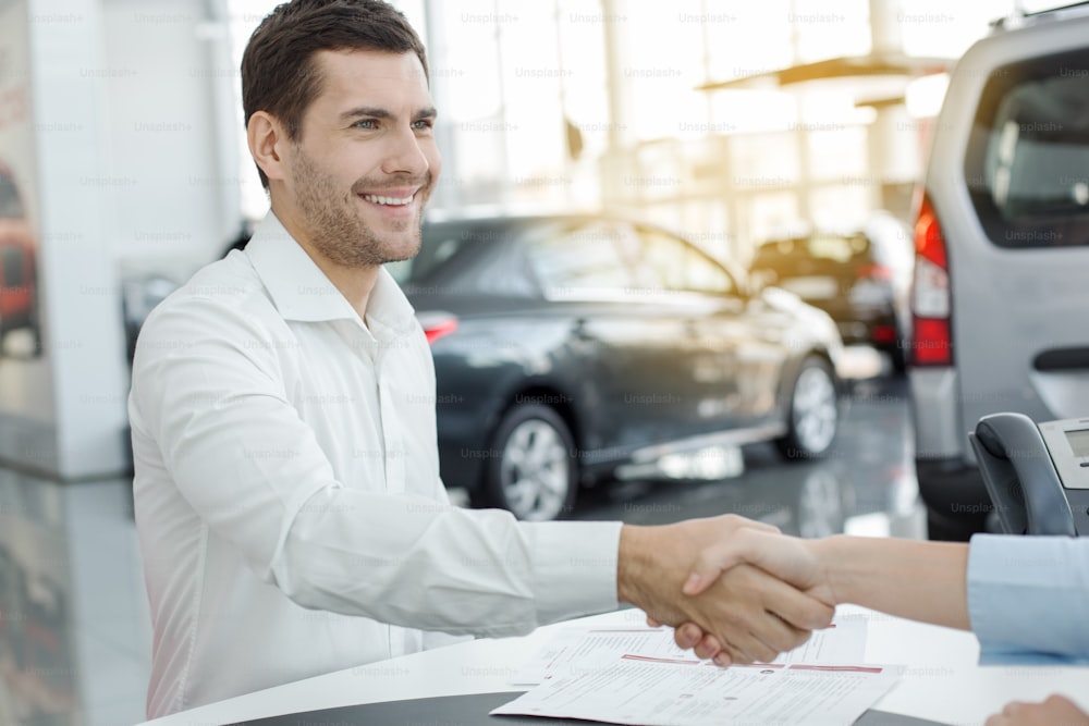 Homem e mulher jovens em um contrato de locação de serviços de aluguel de carros
