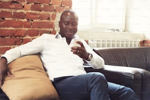 그의 모바일 휴대 전화 스마트 폰에 비즈니스 공식 복장을 한 아프리카 계 미국인 전문 사업가의 이미지