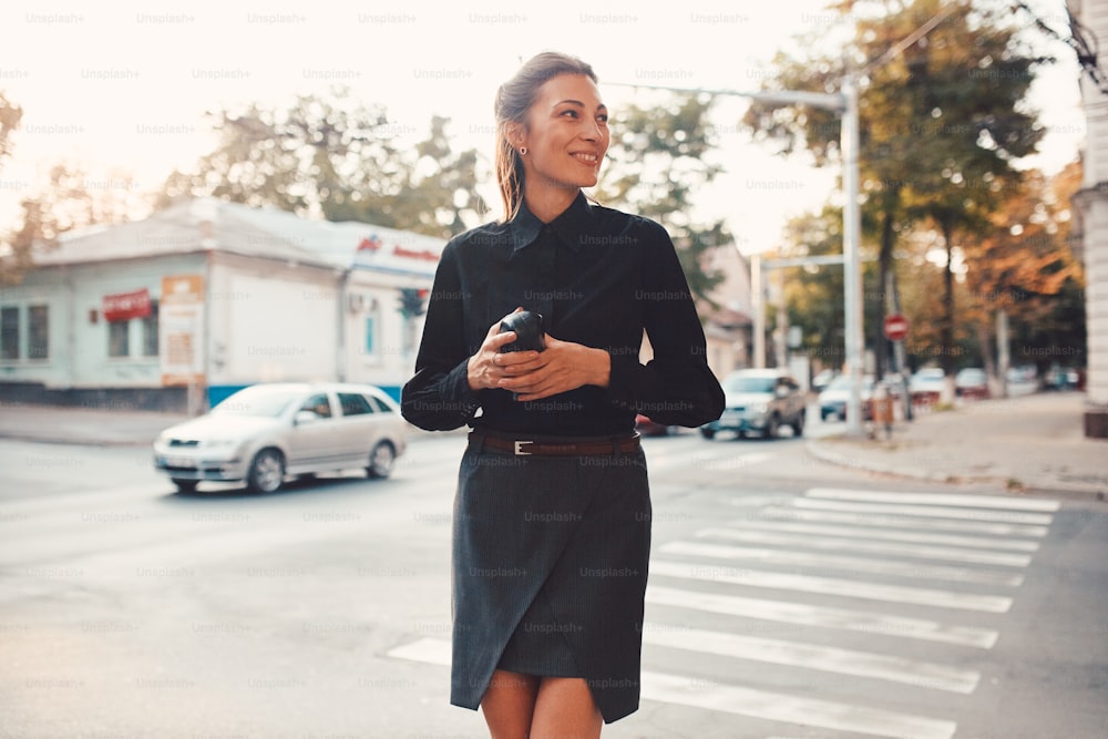 Beautiful brunette young woman walking through the streets of Old City. Fashion concept