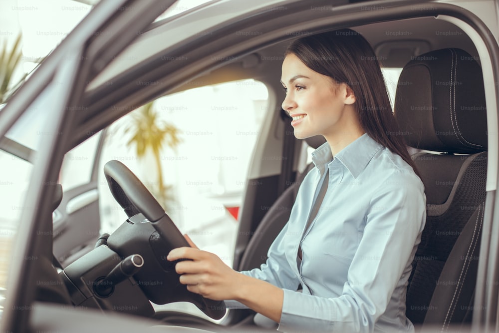 Young woman sitting in a car test drive rental service