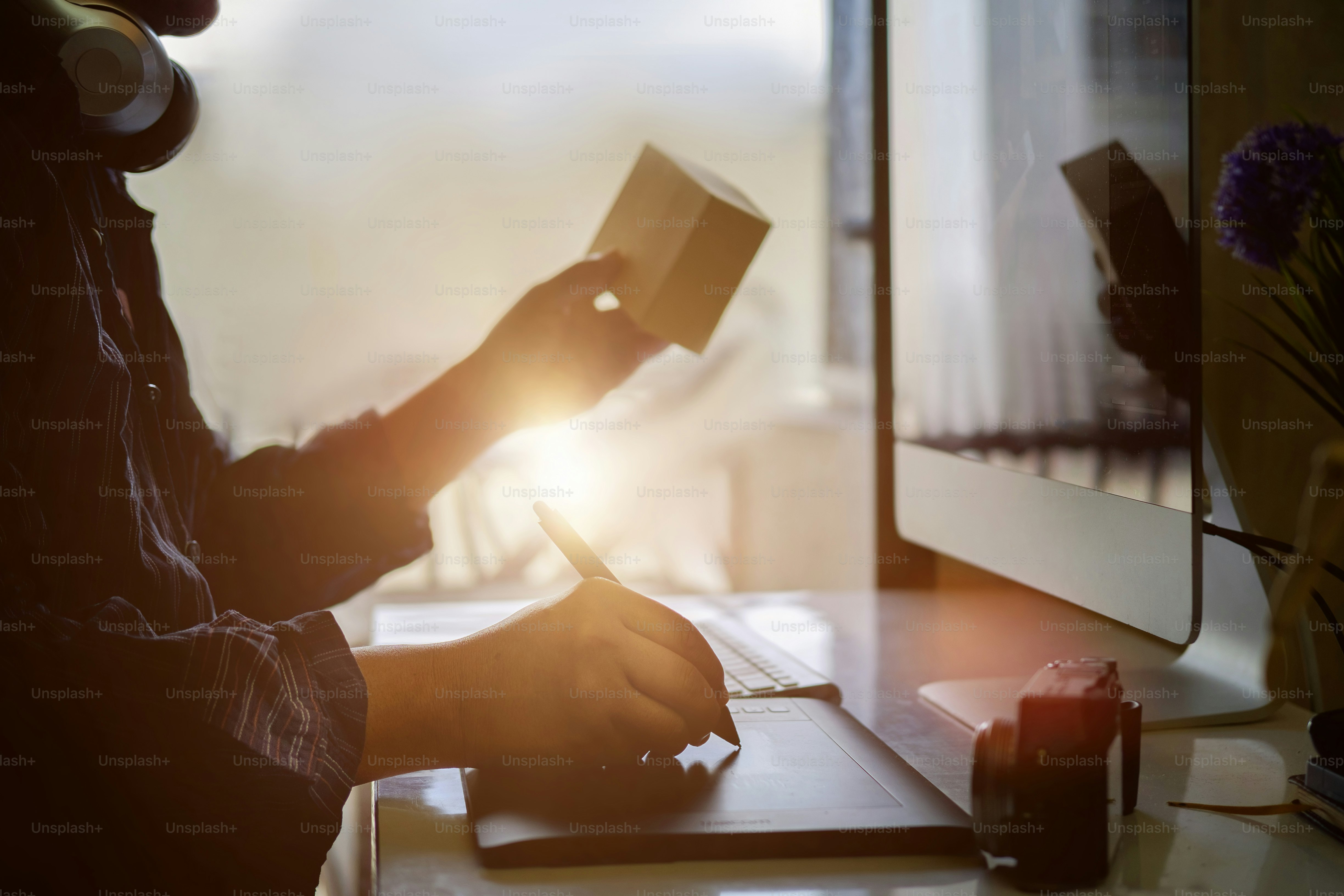 현대 사무실에서 일하는 동안 디지털 그래픽 태블릿을 사용하는 젊은 힙스터 그래픽 디자이너 남자, 나무 테이블, 일반 디자인 태블릿이 있는 현대적인 작업 공간에 앉아 있는 전문 남성 리터쳐.