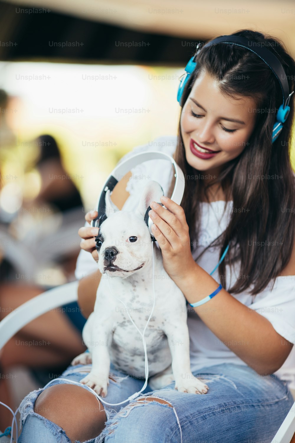 Beautiful young woman sitting in cafe with her adorable French bulldog puppy. People with dogs theme.