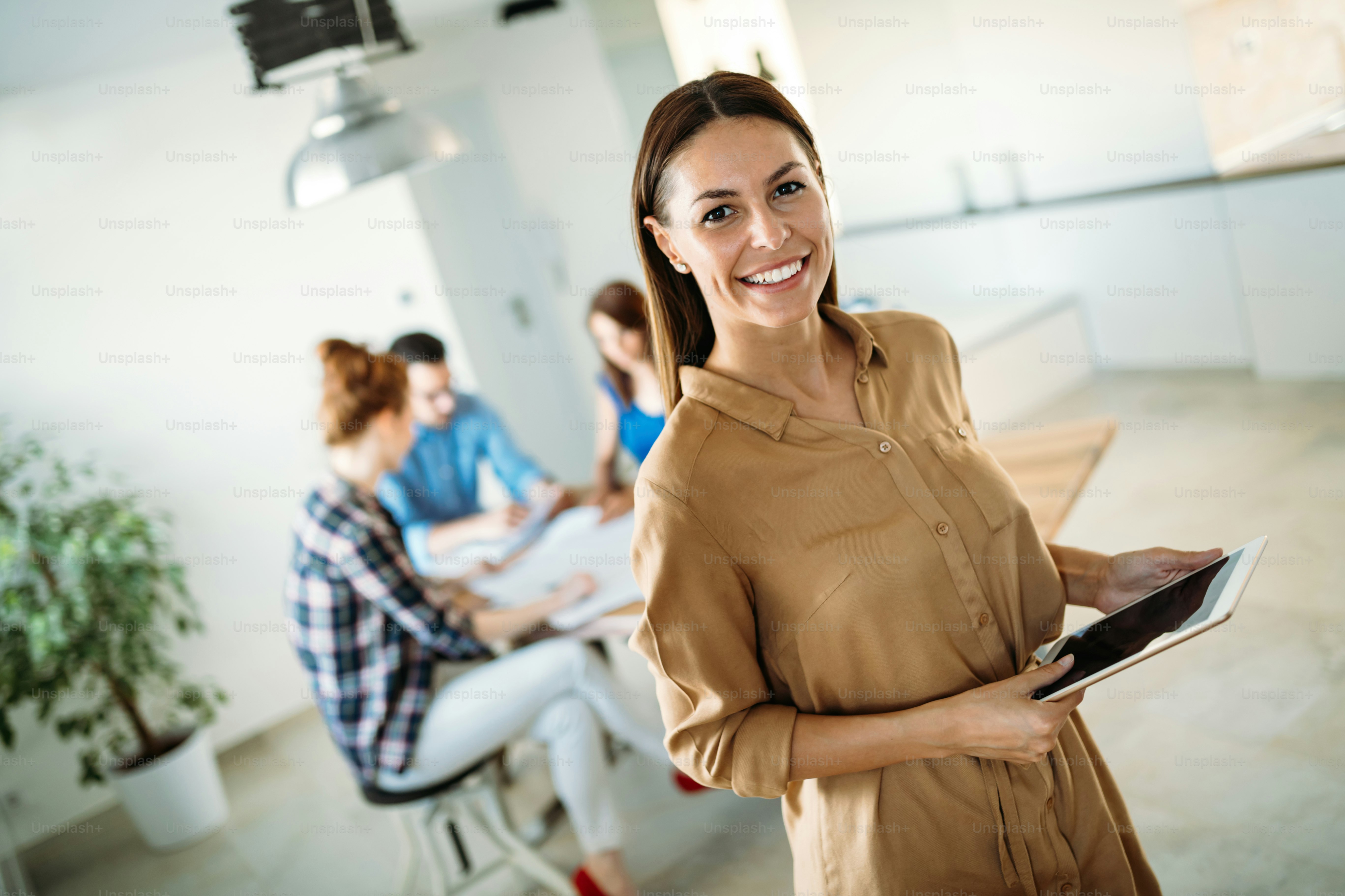 Image of young beautiful business woman holding tablet