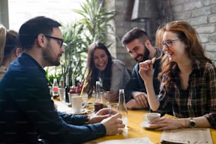 Picture of group of young coworkers socializing in restaurant