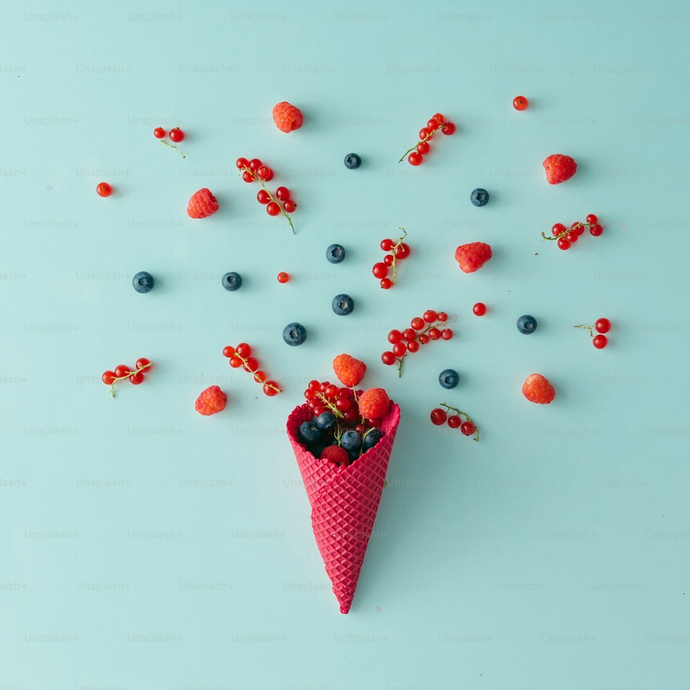 Forest fruit with ice cream cone on blue pastel background. Flat lay. Summer concept.
