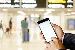 Hombre usando un teléfono inteligente en la cabina de vuelo en la terminal del aeropuerto. Pantalla en blanco para el montaje de la visualización de gráficos.