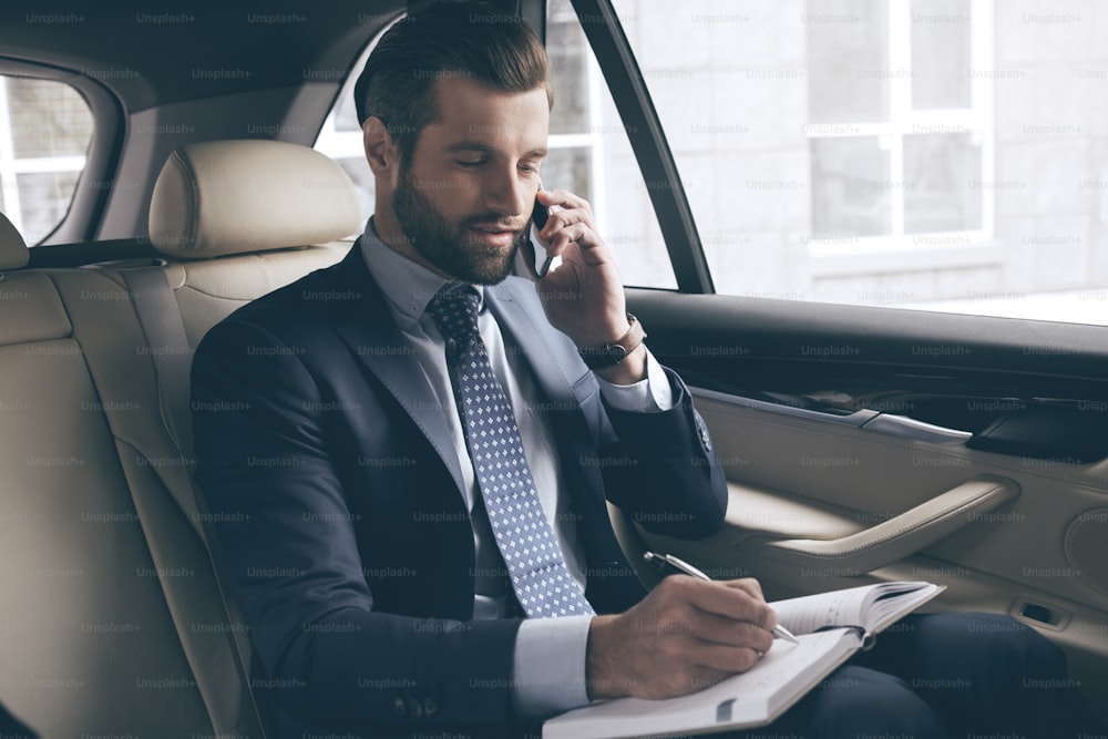 Young business person test drive new vehicle usng digital device
