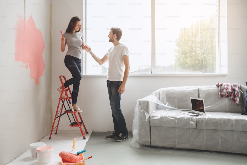 Young man and woman doing apartment repair together come down