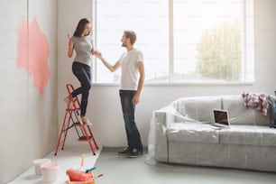Young man and woman doing apartment repair together come down