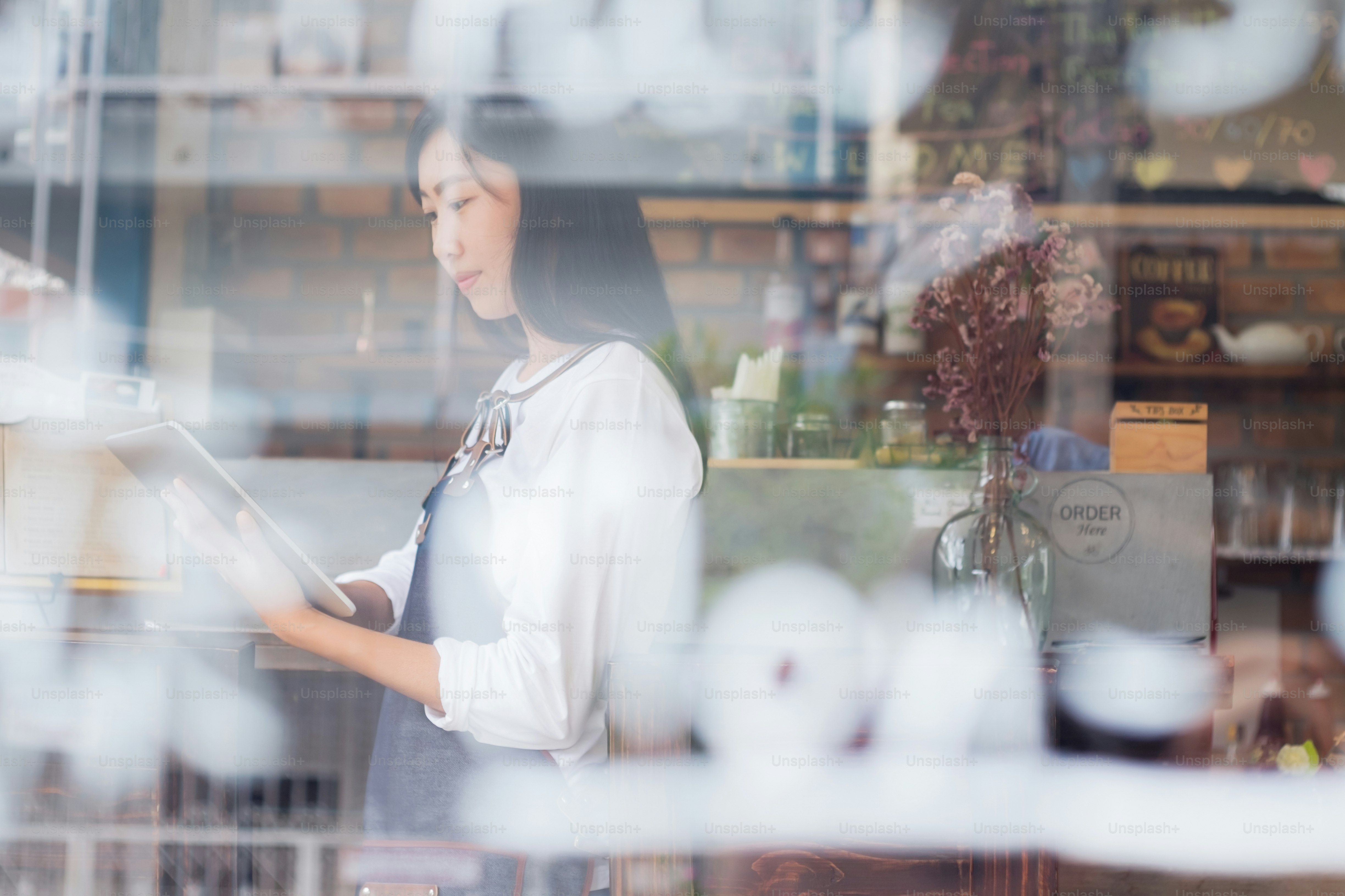 カフェオーナーがタブレットで注文を確認