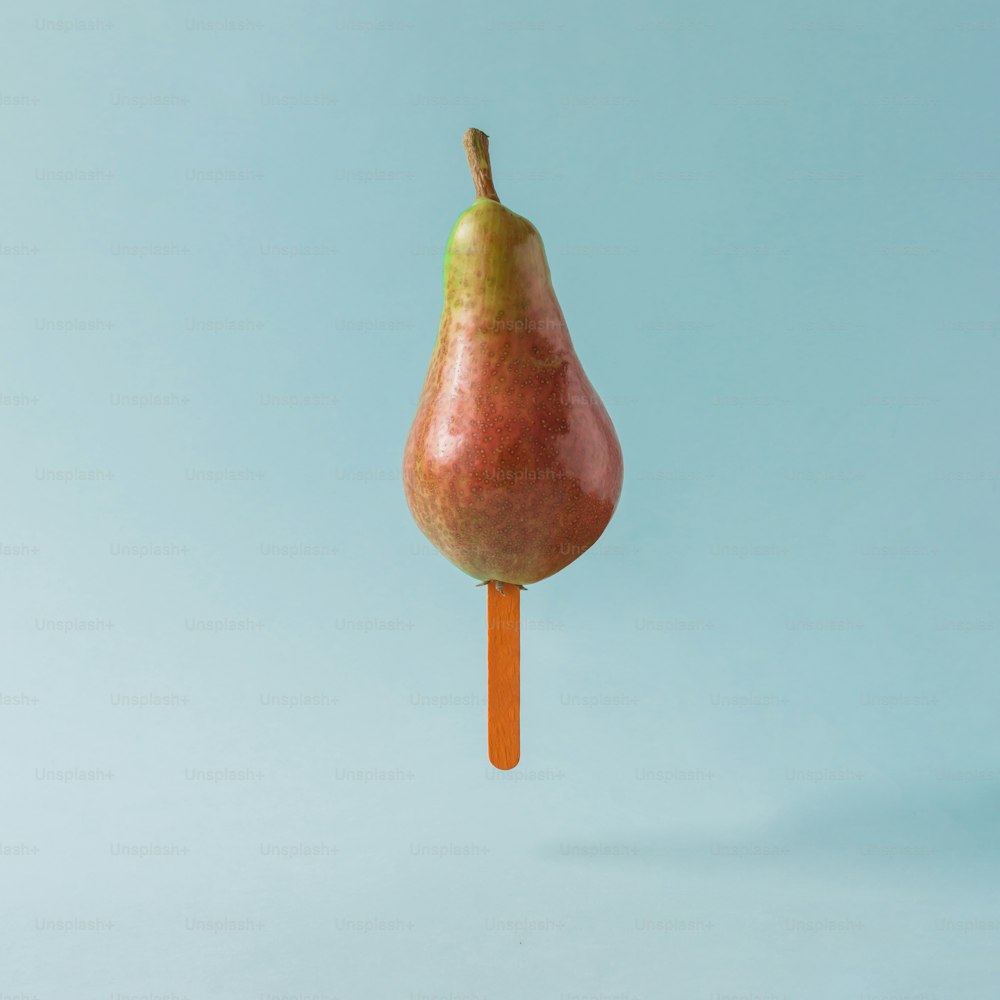 Pear with ice cream stick on pastel blue background. Food creative concept.