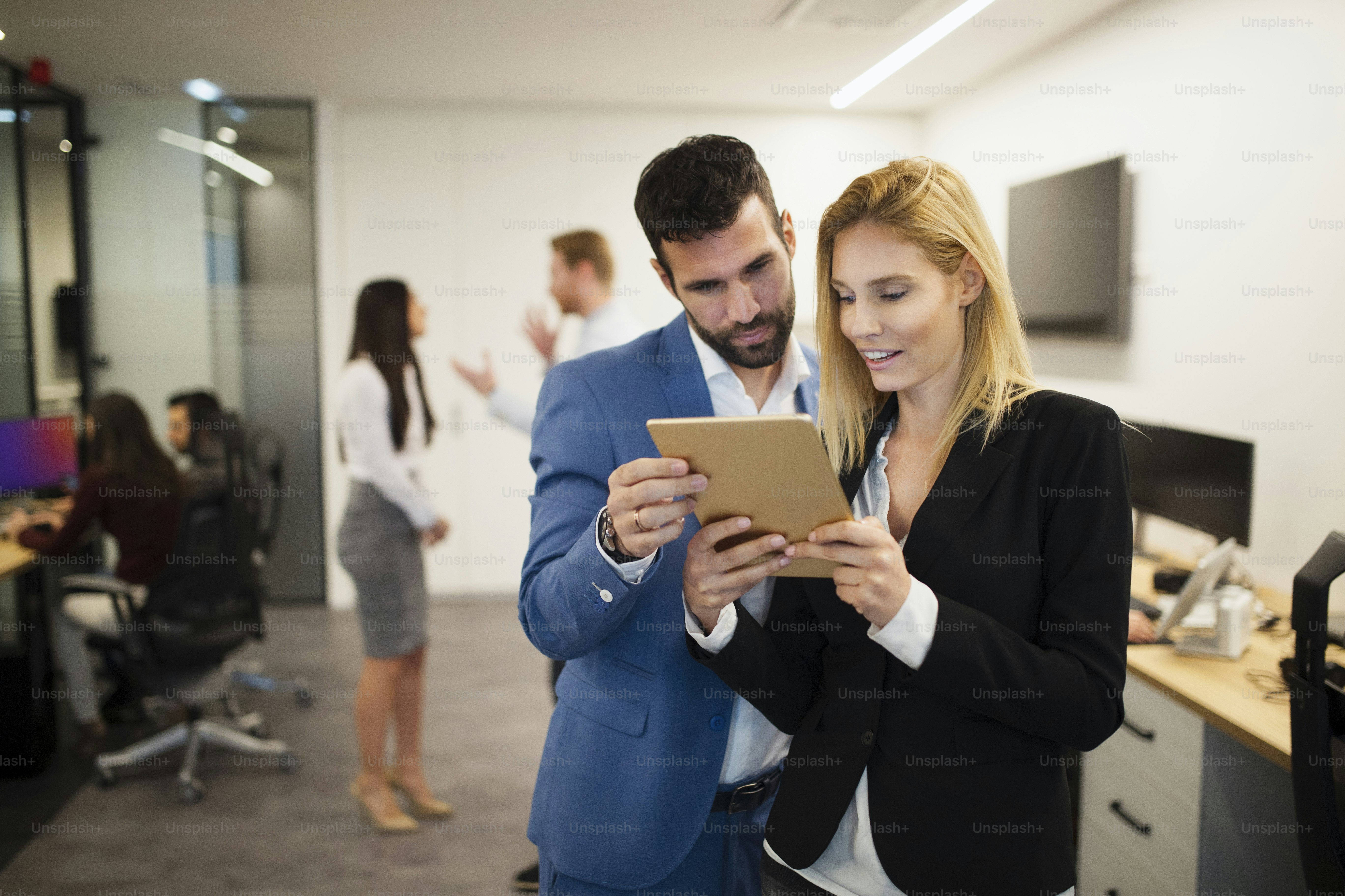 Portrait of attractive business partners using tablet in office