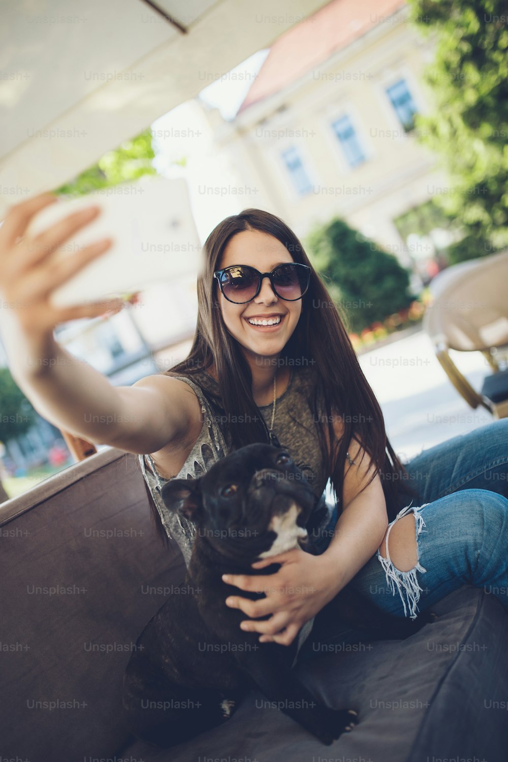 Beautiful teenage girl sitting in cafe restaurant with her adorable French bulldog puppy. People and dogs theme.