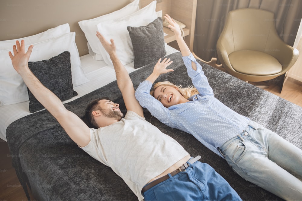 Homem jovem e mulher juntos hotel de turismo deitado na cama
