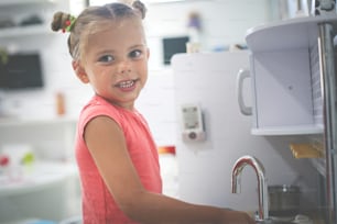Little girl in playground. Girl playing in children kitchen.