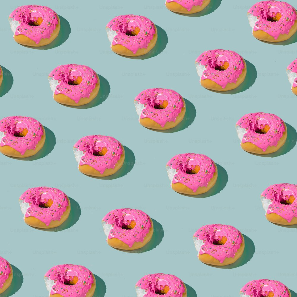 Pink glazed donut pattern on blue pastel background. Creative concept.