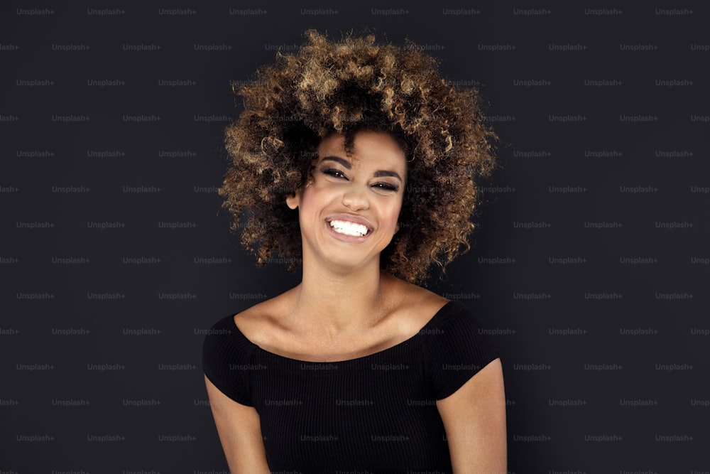 Schönheitsporträt einer lächelnden afroamerikanischen Frau mit Afro-Frisur.
