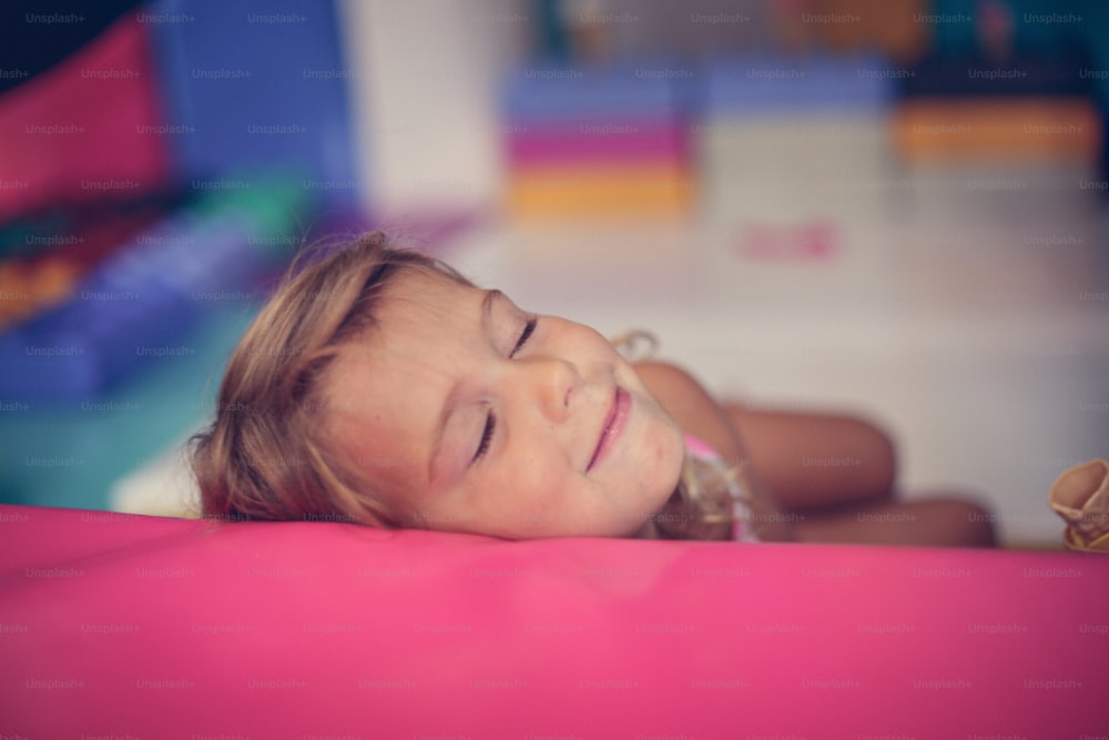 Little girl in playground. Caucasian girl dreaming in playroom.