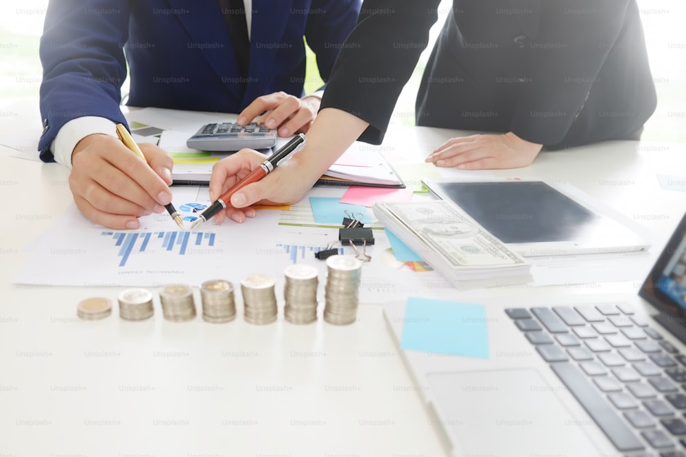 Business adviser analyzing financial,Financial planning Business man and Business woman talking to planner financial business, report finance in paper on office accounting.