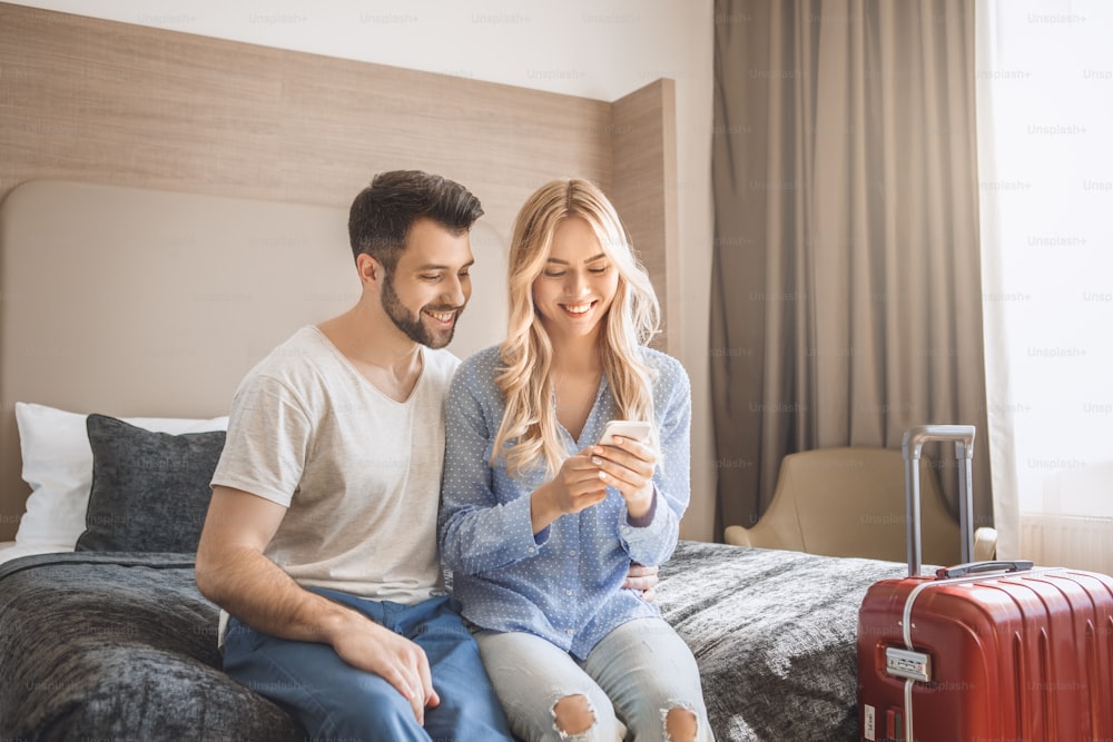Hombre y mujer jóvenes juntos hotel de turismo usando un dispositivo digital