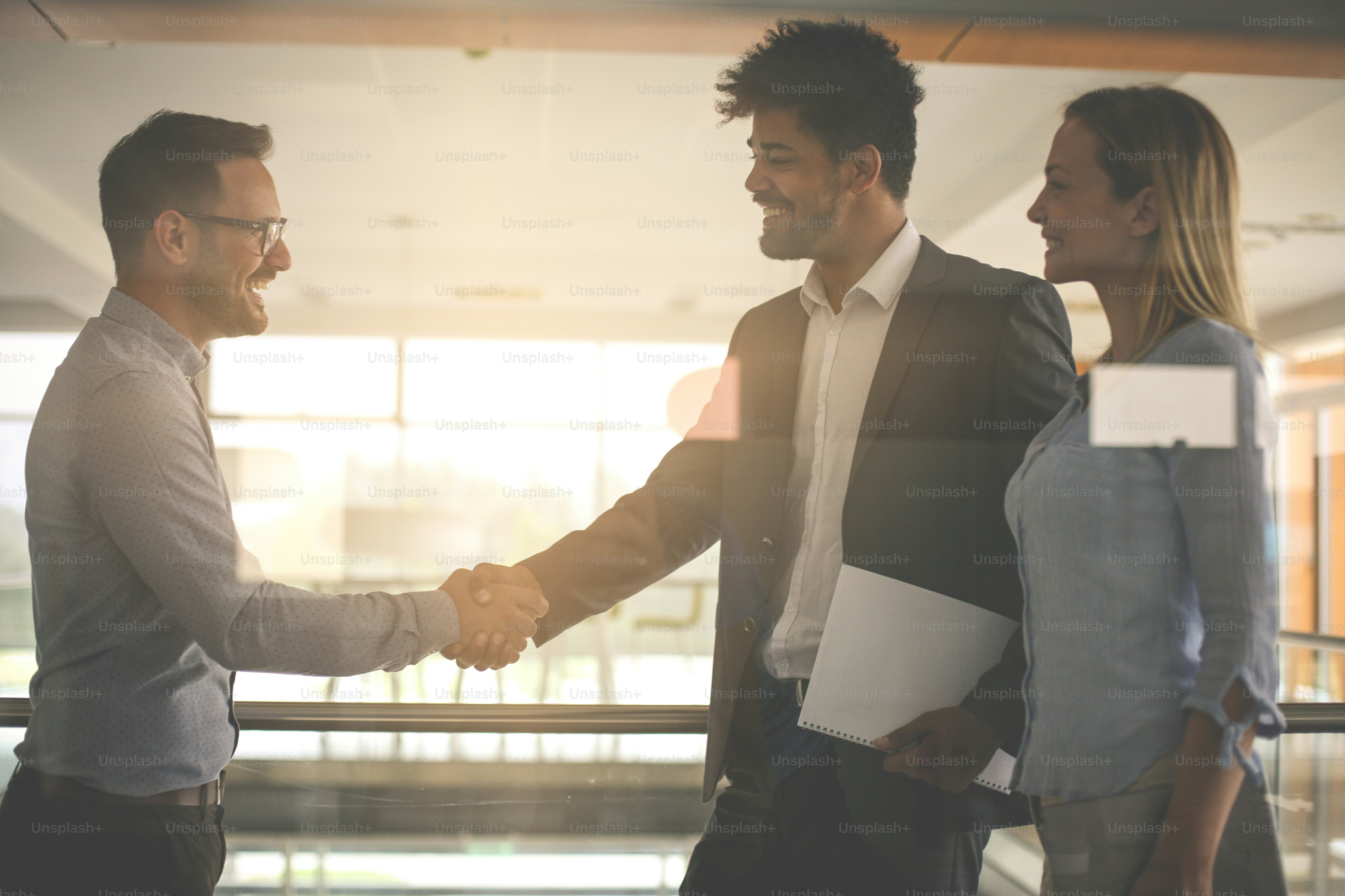 Empresarios dándose la mano en la oficina. Empresarios exitosos.
