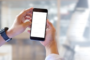 Man holding smartphone with blurred office background. For Graphic display montage.