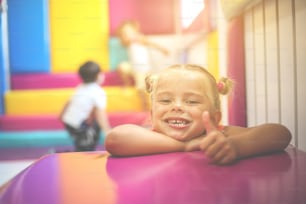 Little girl in playground. Girl showing ok.