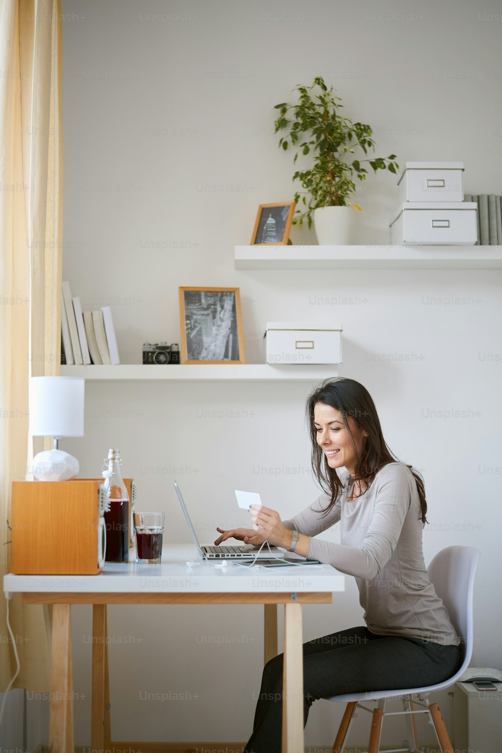Mulher caucasiana bonita usando computador e cartão de crédito para on-line pagando / empresária no conceito dos anos trinta