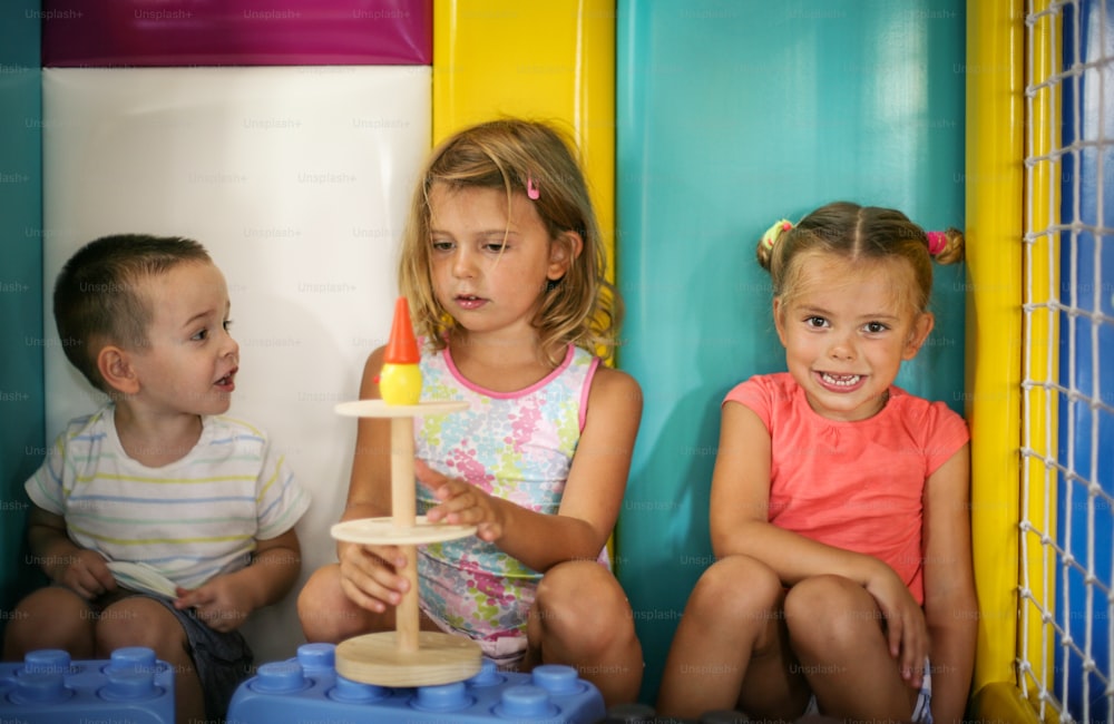 Children in playground. Three child playing together with toys.