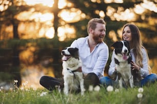 Romantic happy couple in love enjoying their time with pets in nature