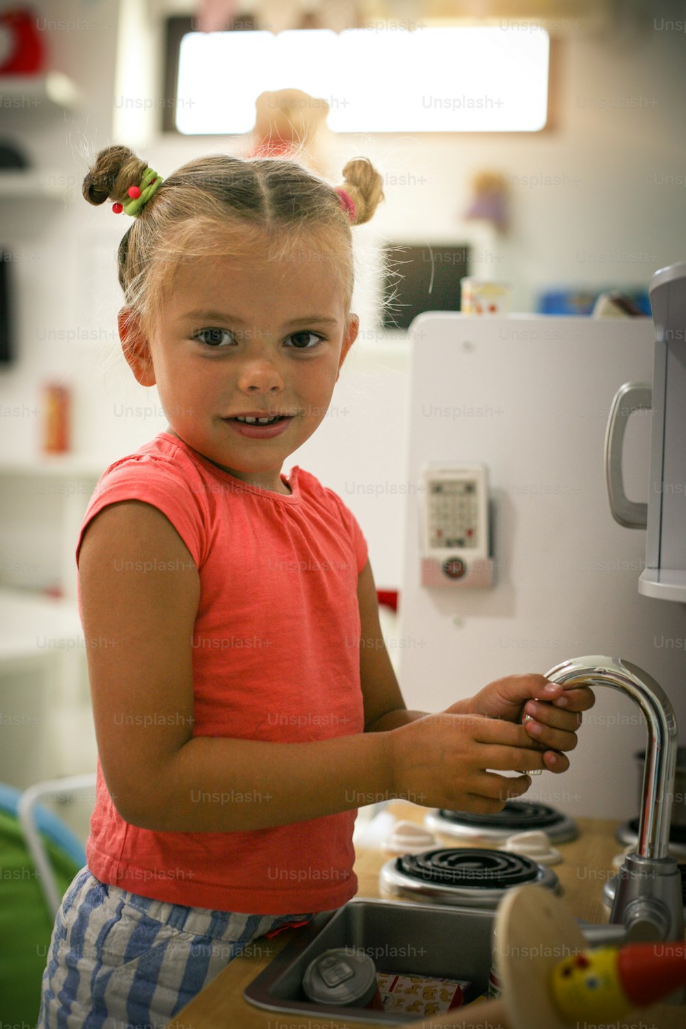 Little girl in playground. Girl playing in children kitchen.