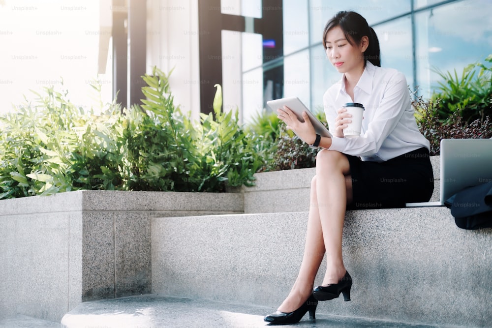 Business woman walking drinking coffee. Lawyer professional or similar walking outdoors happy holding disposable paper cup. Businesswoman smiling happy outside.