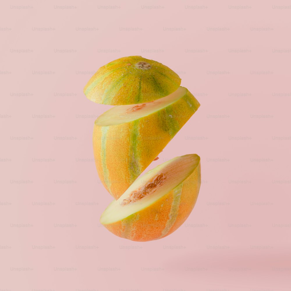 Melone tagliato a fette su sfondo rosa pastello. Concetto di frutta minimale.