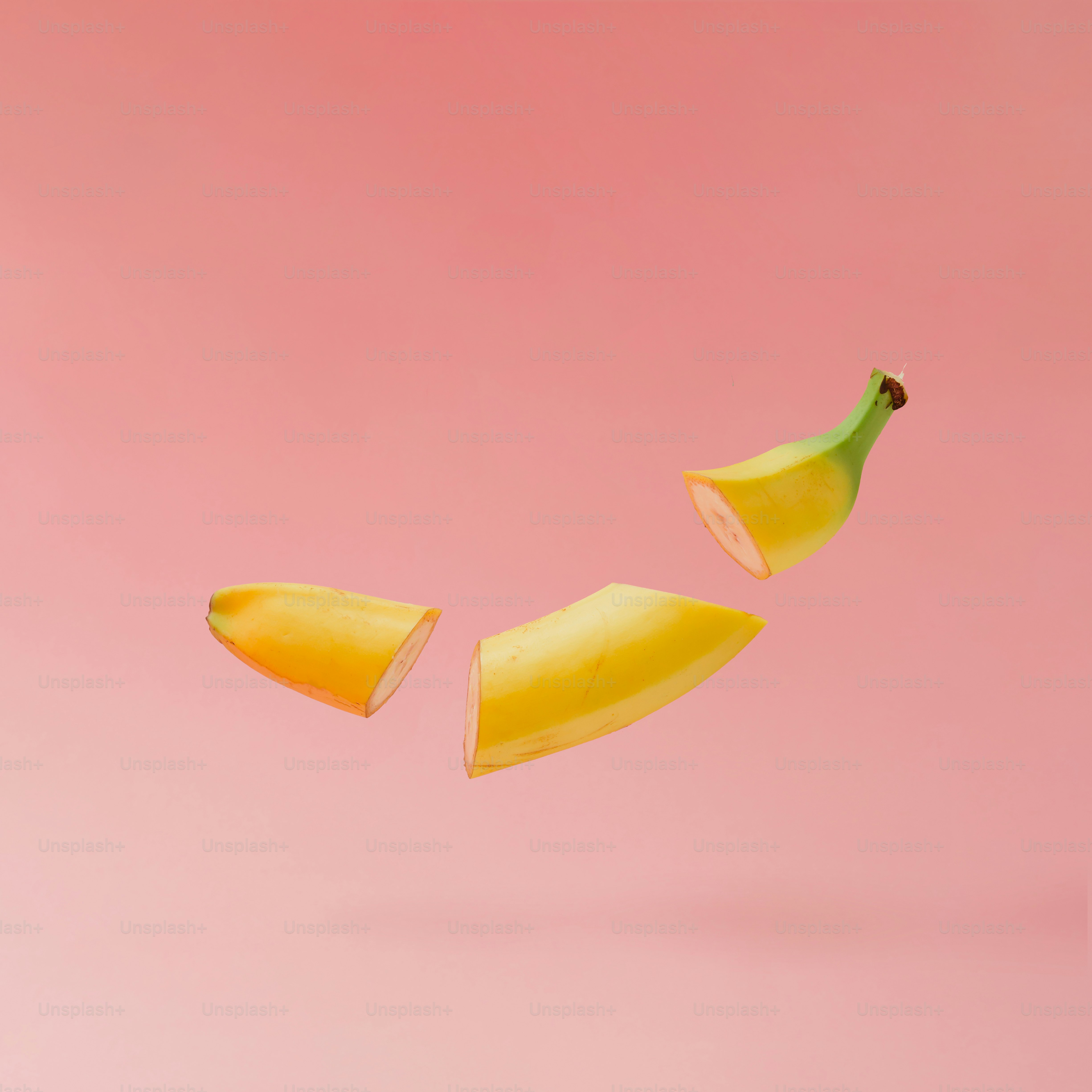 Banana affettata su sfondo rosa pastello. Concetto di frutta minimale.
