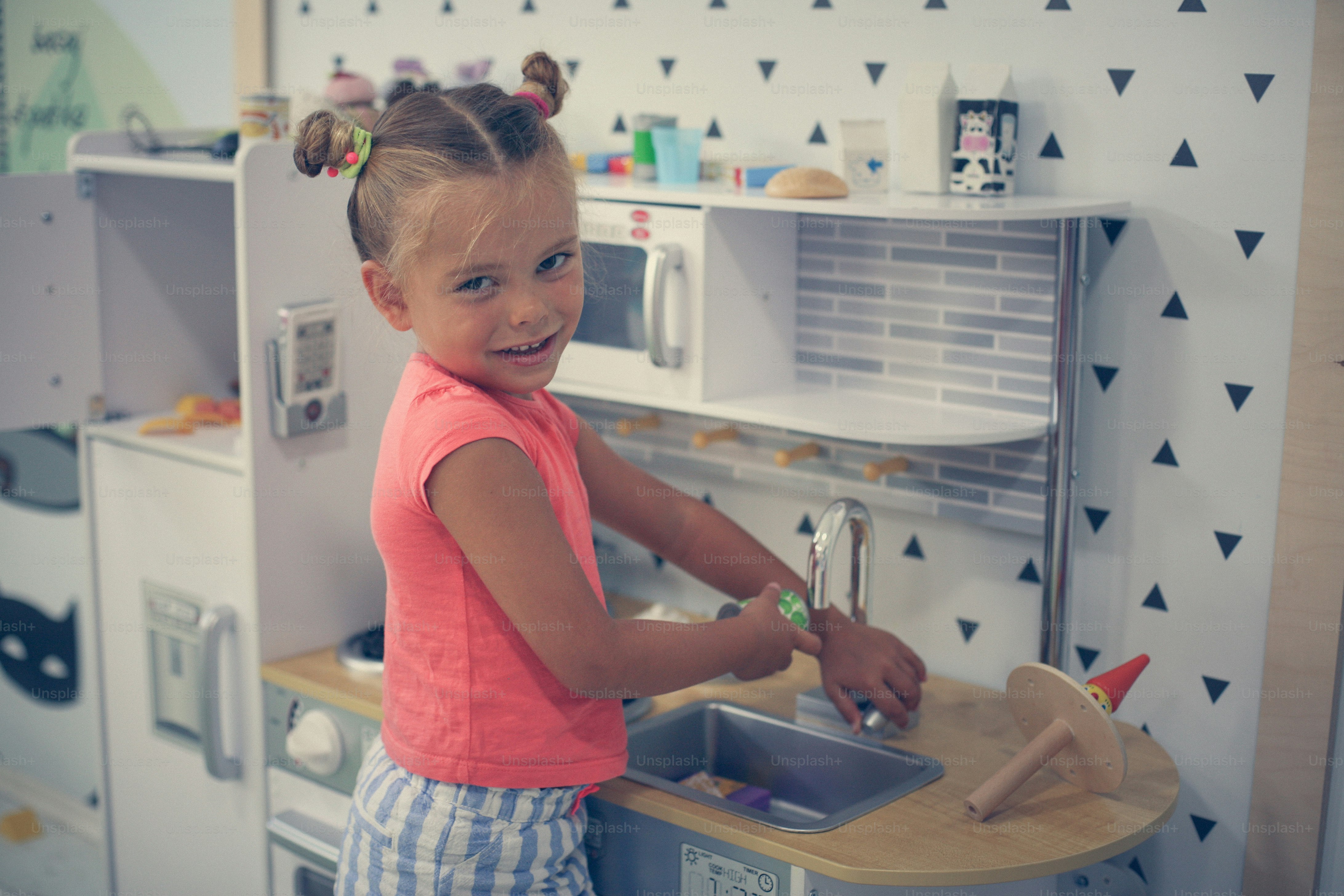 Little girl in playground. Girl playing in children kitchen.