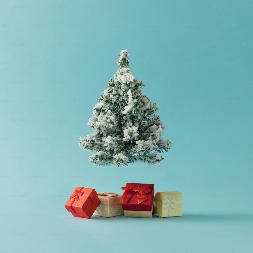 Albero di Natale con scatole regalo su sfondo blu brillante. Concetto di vacanza minimale.