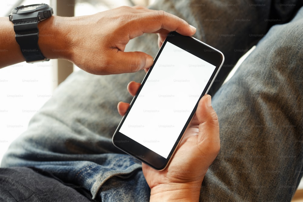 Over the shoulder view of person relaxing while using smartphone blank screen for graphics display montage.