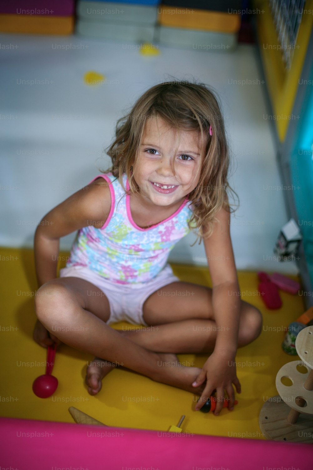 Petite fille dans l’aire de jeux. Fille caucasienne jouant avec un jouet. Regarder la caméra.