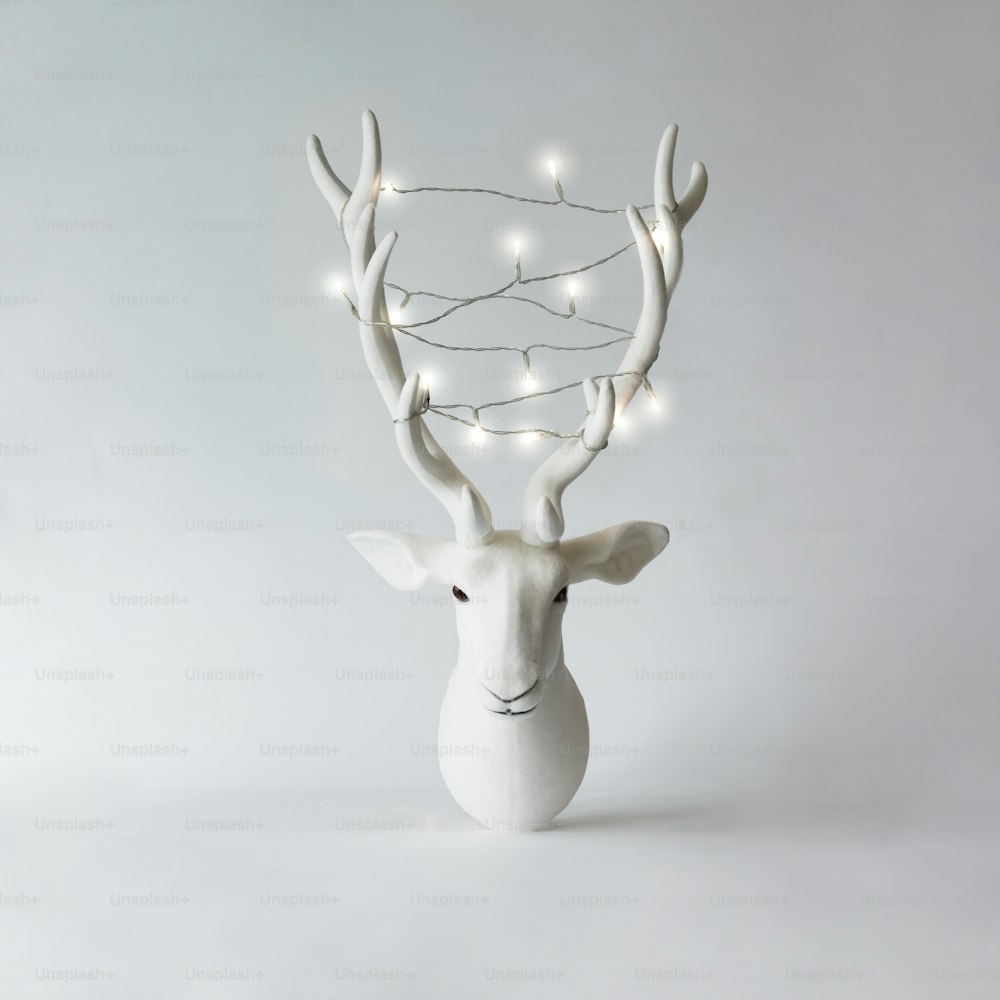 White Christmas reindeer head with antlers with christmas lights. New Year concept.