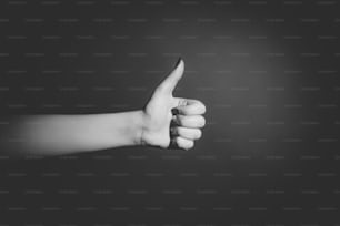 Mão humana mostrando o gesto como, OK, super no fundo preto
