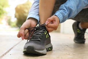 Deportista atando cordones de zapatos. Deportista atándose los cordones de los zapatos antes del entrenamiento. Cerrar.
